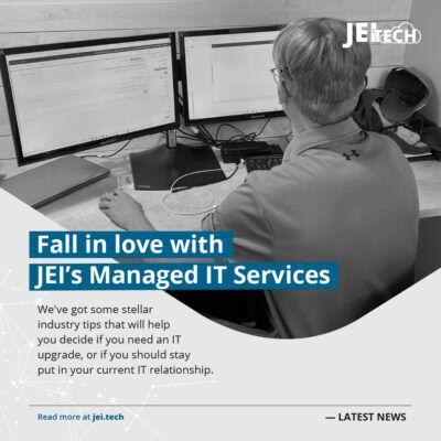JEI Tech worker, looking at computer screen. The message "Fall in love with JEI's managed IT services"